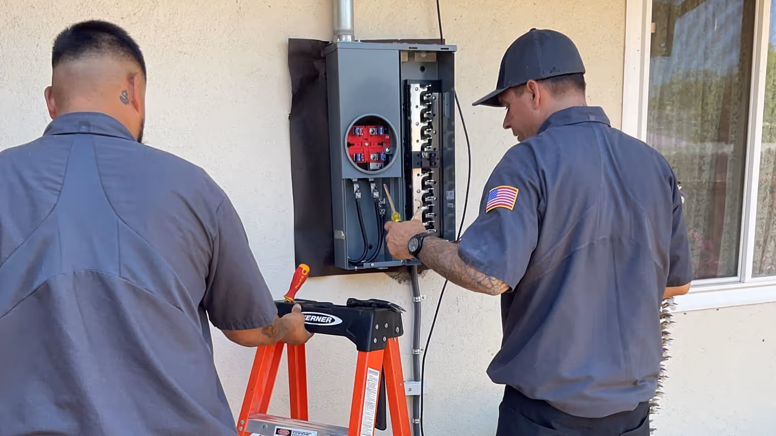 AAA technicians working together at a Sacramento-area home's electrical panel